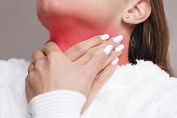 Woman touching sore throat with red highlighted area. Concept of illness and pain. Medical symptom of flu cold or infection. Health problem closeup. Human body sickness background.