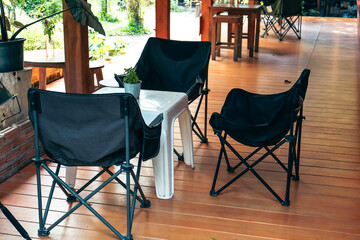Cozy indoor lounge, modern folding chairs arranged around a small table in a bright, inviting space, perfect for gathering.