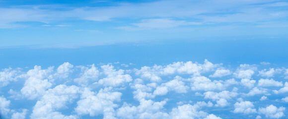 Beautiful landscape view trough window of airplane and cloudless sundown sky behind window of aircraft during flight. blue sky. Flying in the sky and the sea of clouds.