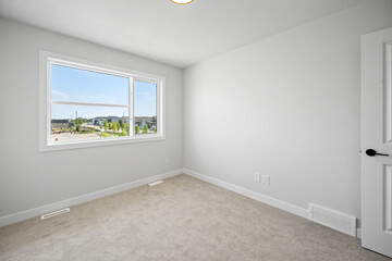 Large window in a white room with a view of the city