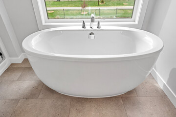 Fototapeta premium White bathtub with a faucet and a window above it