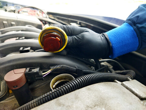 Working on a car engine coolant system during maintenance