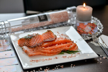 Salmon on a plate with a candle and spices in the background