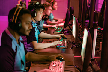 A focused team of gamers competing in a thrilling esports tournament with vibrant lighting in the venue