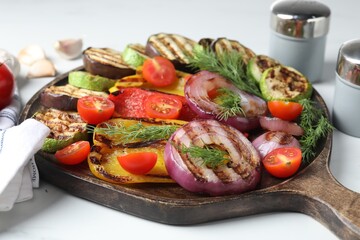 Vegetarian barbecue. Tasty grilled vegetables served on white marble table, closeup