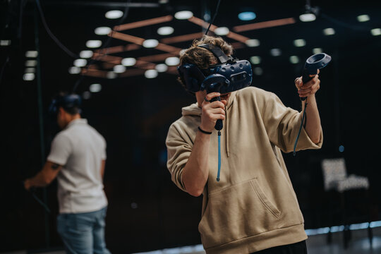 Two individuals immersed in a virtual reality gaming session, showcasing technology and modern entertainment in a digital gaming room atmosphere.