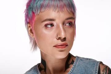 Young woman with vibrant short hair posing in a bright studio setting