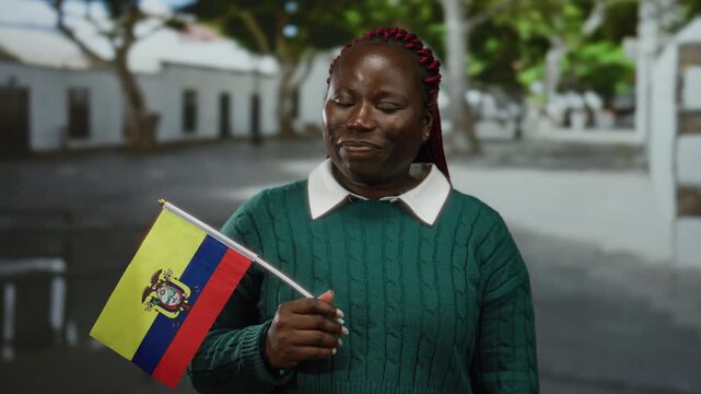 Woman smiling holding ecuador flag in city street representing multicultural pride and diversity in urban outdoor setting with blurred background
