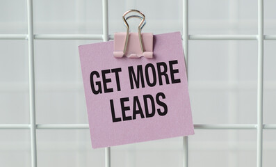 A pink note with a clip on it that says Get more leads