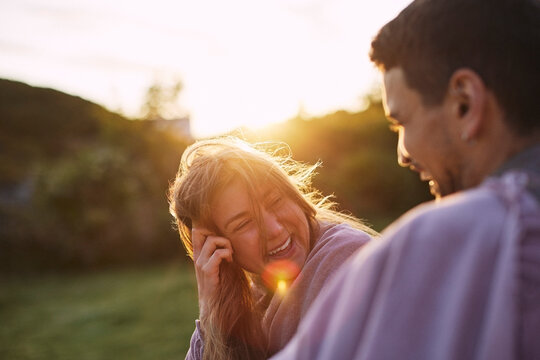 Sunlight shining on happy woman enjoying leisure time with boyfriend during summer vacation