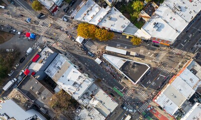 Aerial view of a bustling street scene with crowds, runners in the New York Marathon, and buildings casting long shadows under the clear sky, Brooklyn, New York, United States.