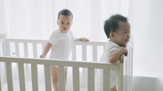 Two twin babies playing in their crib