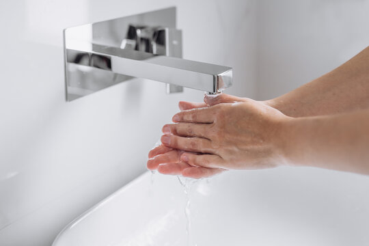 Close-up of hands being washed under running water with soap, highlighting hygiene, purity and responsible water consumption. Concept of cleanliness, health protection, eco awareness and sustainable l