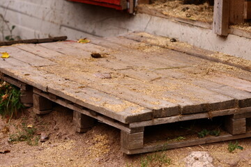 A simple wooden pallet sitting on a dirt ground, great for rustic or outdoor scenes
