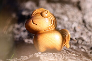 A small wooden horse sits atop a rock, surrounded by natural scenery