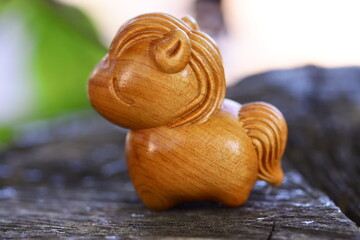 A small wooden toy horse sits on top of a wooden table, perfect for decoration or as a prop in a scene