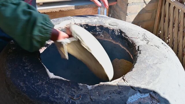 Bread baking in a tandoor oven in Khiva, Uzbekistan