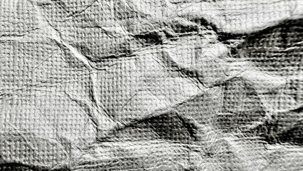 Obraz premium metallic silver crumpled fabric texture with embossed grid pattern and deep shadows for abstract wallpaper or modern banner background