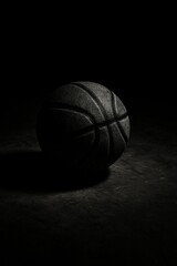 Basketball under Shadow: A singular basketball stands in stark relief against a darkened backdrop, capturing the essence of the game