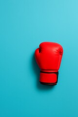 Red Boxing Glove on Blue: A vibrant red boxing glove, a symbol of strength and determination, rests against a vivid blue backdrop, exuding power and grit.