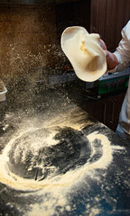 Pizzaiolo fazendo um malabares com a massa de pizza