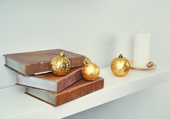 Vintage Christmas still life with golden ornaments and old books.