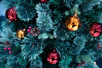 close up decoration ball and light bulb bokeh on snow blue green Christmas tree at night time on holiday xmas theme