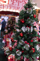 A festival cozy holiday Christmas tree with snowy branches , candy cane, red apples , glowing lights, and a cheerful gingerbread man and festive ornaments bringing warmth to the season.