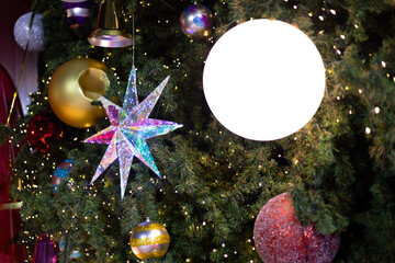 close up multicolor decoration ball with snow star and light bulb on Christmas tree pile tree at night time on holiday snowy xmas theme in december 
