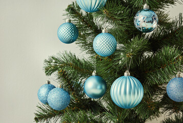 A modern Christmas tree decorated with blue textured ornaments.