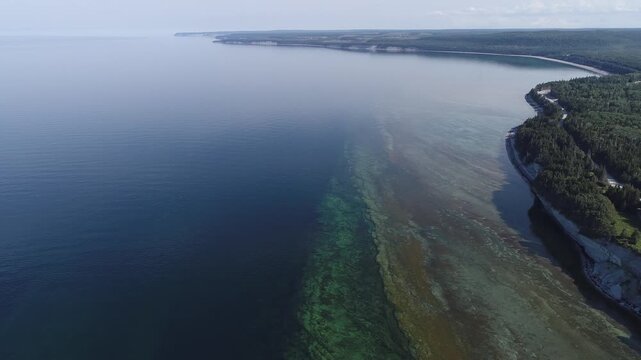 Cliffs, Lighthouse, and Vast Forests overlook the Blue Waters at Pointe Carleton on Anticosti Island, where Coastline, Horizon, and Wilderness create a Majestic, Remote, and Scenic Panorama