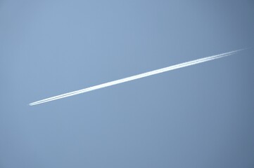 The trajectory of an airplane across the blue sky. This trajectory is the trace left by an airplane as it passes through the sky, which is created by combining with atmospheric water vapor.