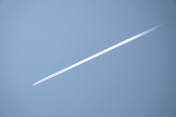 Airplane in the sky. The trajectory of an airplane across the blue sky. 