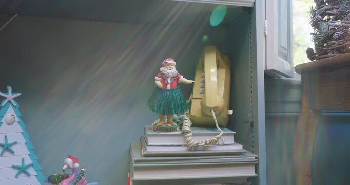 Hula Santa figurine beside a vintage yellow wall phone