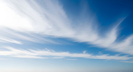 Fototapeta premium Wispy clouds paint the vast blue sky with ethereal beauty
