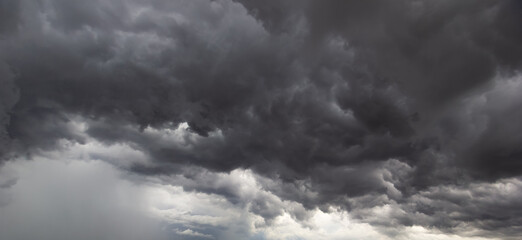 Dark storm clouds gather in the sky creating a dramatic and moody scene,signaling approaching...