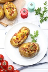 Tasty stuffed baked potatoes on white wooden table, flat lay