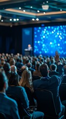 Audience Member Raising Hand During Corporate Conference Presentation with Speaker and Blue Bokeh Screen in a Large Convention Hall