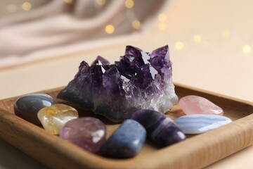 Different beautiful gemstones on beige background, closeup