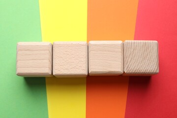 Blank wooden cubes on color background, flat lay