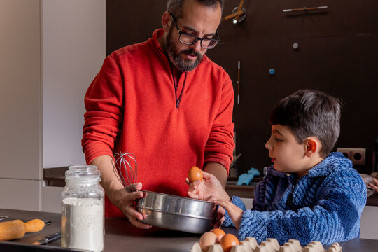 Father and alpha generation son cooking together on the kitchen
