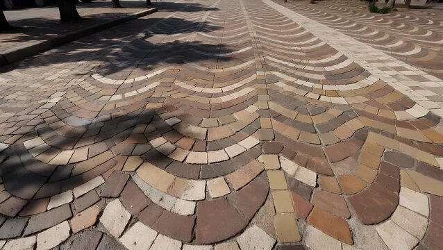 Traditional Cal&ccedil;ada Portuguesa Patterned Cobblestone Pavement Featuring Wave-Like Motifs