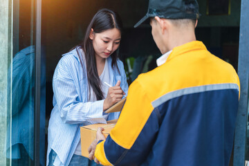 Young Woman Receives Package at Doorstep from Delivery Person in Casual Clothing During Daylight in Urban Environment