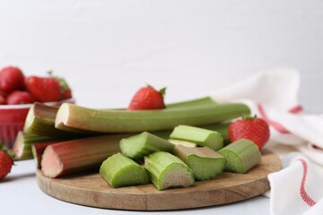 Fresh rhubarb and strawberries on white table, closeup