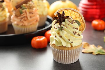 Delicious cupcake with sprinkles and spices on grey table, closeup with space for text. Autumn atmosphere