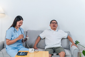Nurse conducting a health check on a senior patient sitting comfortably on a couch in a cozy home environment with medical equipment nearby