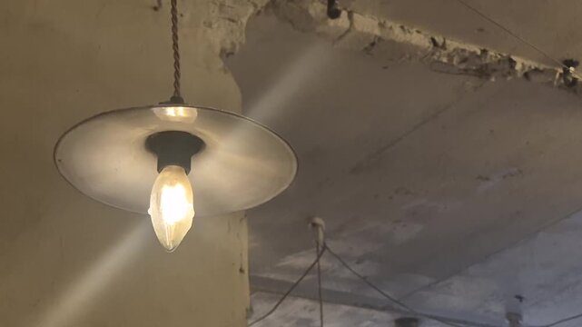 Minimal industrial style pendant light with exposed bulb, warm glow and rustic ceiling interior design element