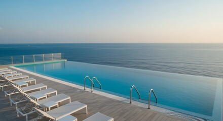 Luxury Infinity Pool Overlooking the Ocean at Sunset with Lounge Chairs and Clear Sky