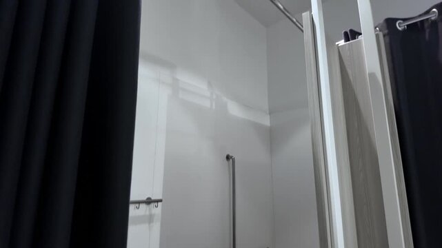 Spacious accessible fitting room with grab bars and a sturdy bench provides an inclusive and comfortable shopping experience, promoting universal design in retail
