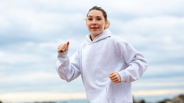 Happy young woman jogging outdoors